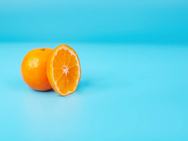 istock Orange tangerine slice on blue background 1340561372