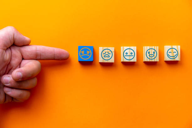 istock Customer service assessment and satisfaction survey ideas were chosen by the client's hand on a wooden cube with a blue backdrop. 1340564607