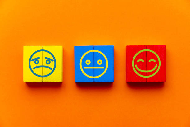 istock Customer service experience and satisfaction survey concept with facial expressions negative, neutral and positive on wooden cube on table, orange background 1340564648