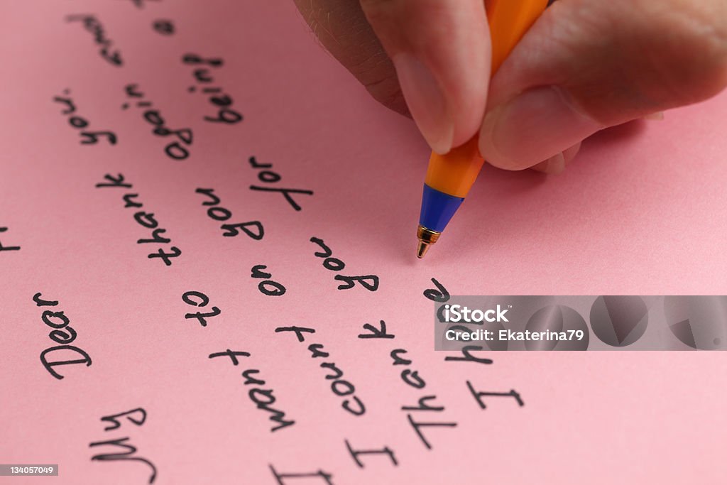 Writing letter to a friend Writing letter to a friend on pink paper. Close-up Stock Photo