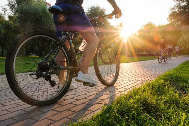 man rides a bike outdoors in the park on a sunny day at sunset - park stockfoto's en -beelden