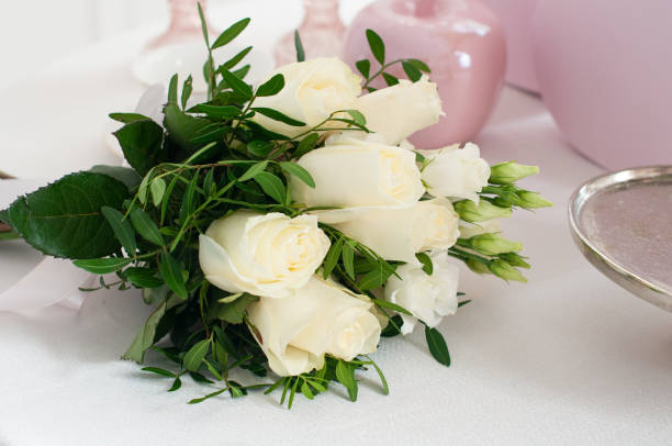 istock Wedding bouquet of white roses on the white table 1340572210