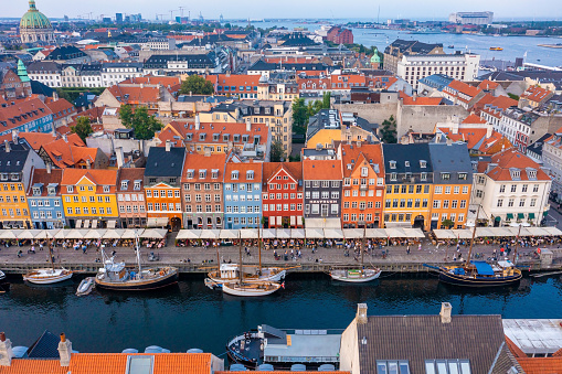 Copenhagen, Denmark. August 10, 2021. Aerial view of famous Nyhavn pier with colorful buildings and boats in Copenhagen, Denmark. The most popular place in Copenhagen.