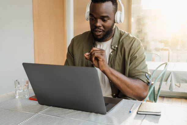 istock African american man using computer laptop for video call meeting at bar restaurant - Focus on face 1340576295