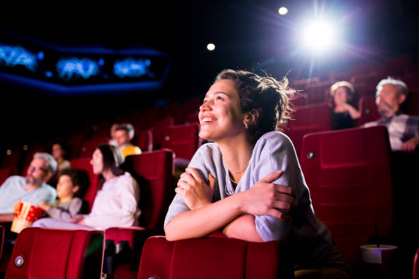 映画館で素敵な映画を見て楽しんでいる女の子 - 封切り ストックフォトと画像