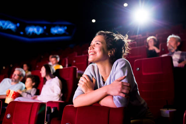 girl enjoying watching a nice movie at the cinema - theater publiek stockfoto's en -beelden