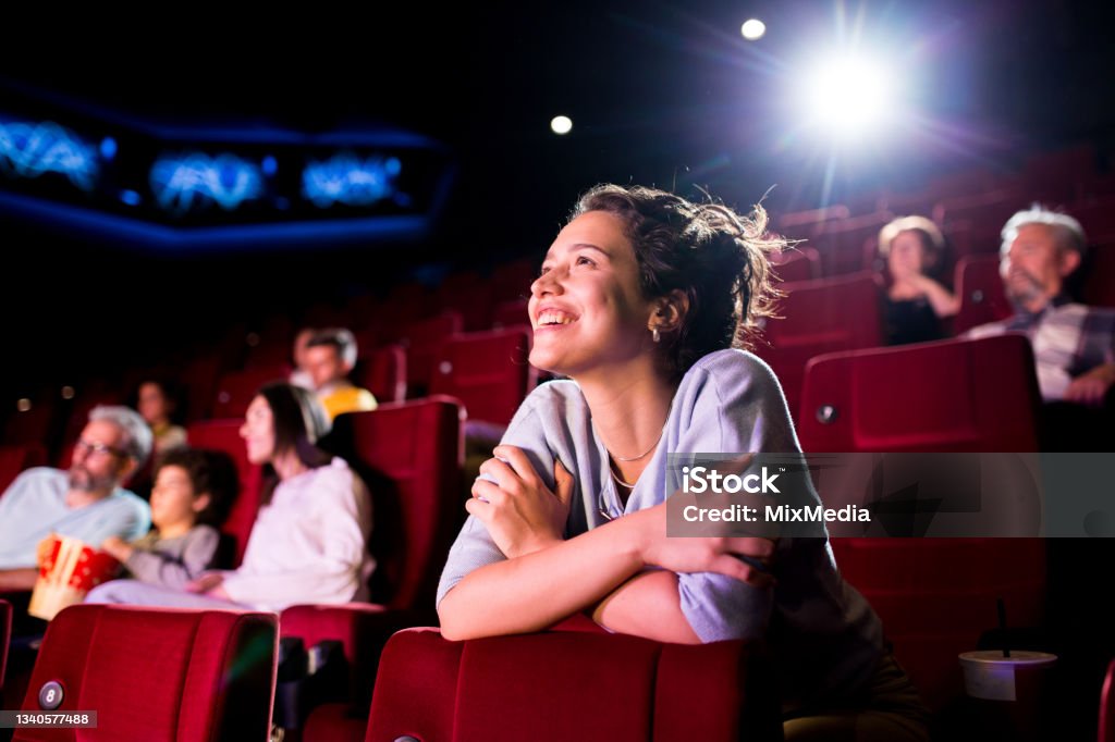 Girl enjoying watching a nice movie at the cinema Girl watching a movie at the cinema and enjoying. Movie Theater Stock Photo