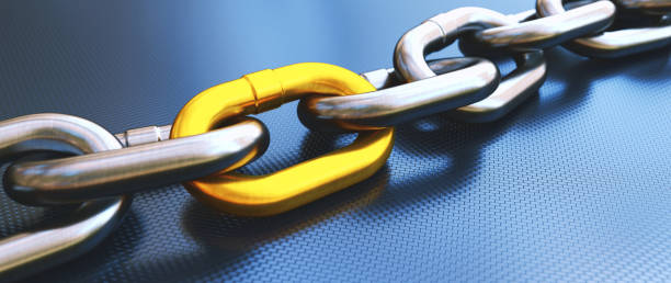 Close up on a heavy chain with a yellow link, laying on a blue carbon fiber surface. Wide horizontal composition. Close up on a heavy chain with a yellow link, laying on a blue carbon fiber surface. Wide horizontal composition. durability stock pictures, royalty-free photos & images