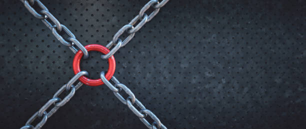 istock Scratched metal ring connecting four chains in an X shape on an dark industrial surface. Close up, wide horizontal composition. 1340580905