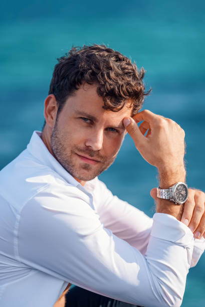 istock Confident man in white shirt against sea 1340586397