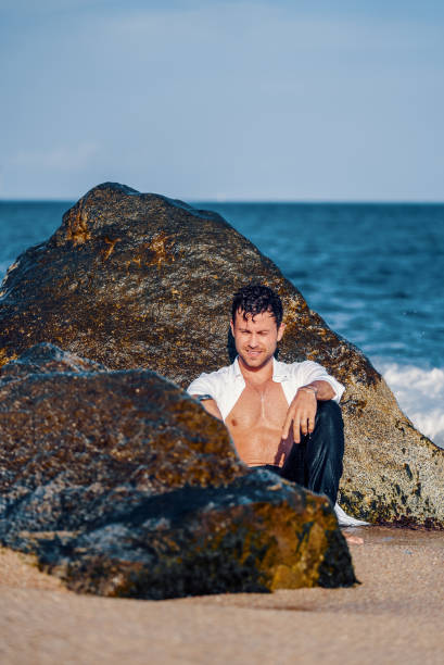 istock Smiling stylish man on rocky coast 1340588812