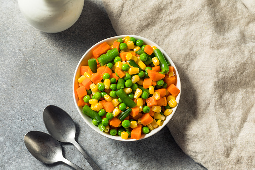 Beef stew with potato, green beans, carrot, celery, peas and corn, in ceramic bowl, horizontal, copy space