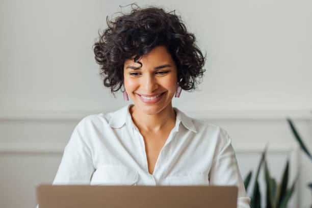 istock Beautiful Woman Working on Laptop Computer at Home 1340589247