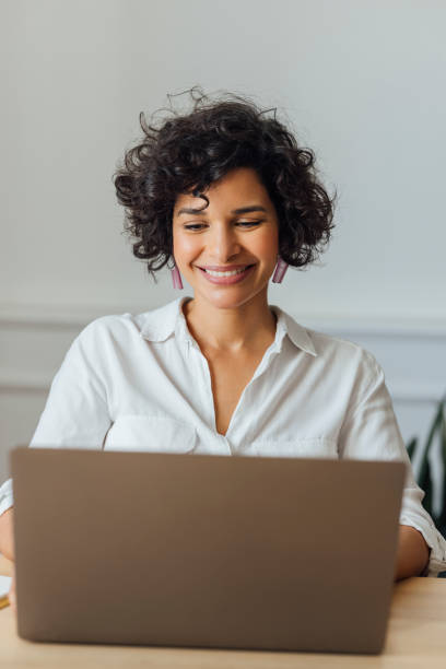 istock Beautiful Woman Working on Laptop Computer at Home 1340589253
