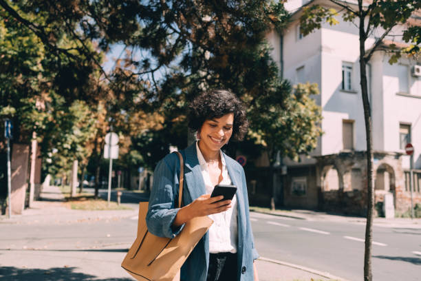 istock Beautiful Woman Using Mobile Phone Outdoors 1340589276