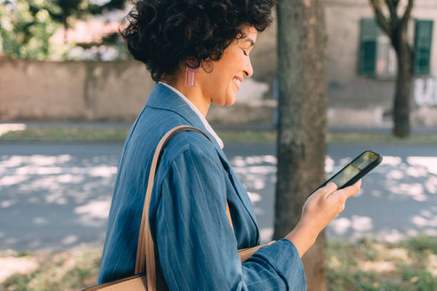 istock Beautiful Woman Using Mobile Phone Outdoors 1340589278