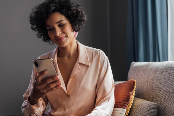 istock Beautiful Woman Using Mobile Phone at Home 1340589292