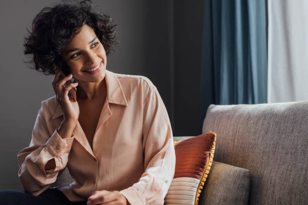 istock Beautiful Woman Using Mobile Phone at Home 1340589305