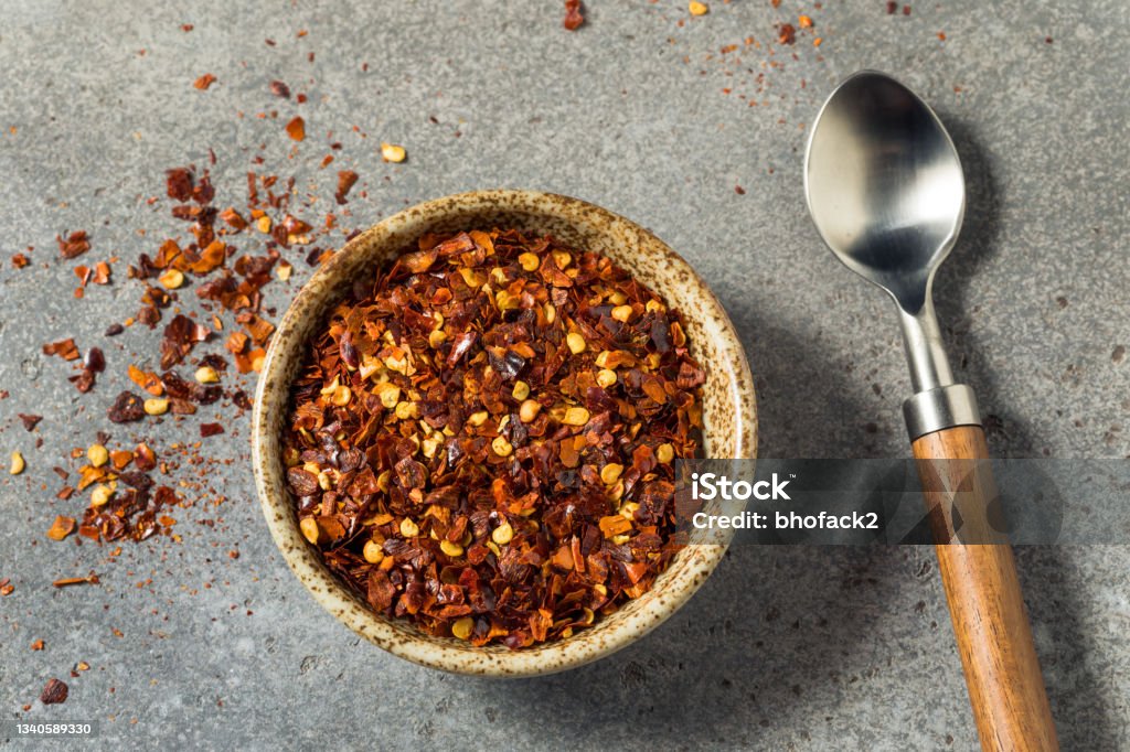 Organic Raw Red Pepper Flakes Organic Raw Red Pepper Flakes in a Bowl Red Bell Pepper Stock Photo