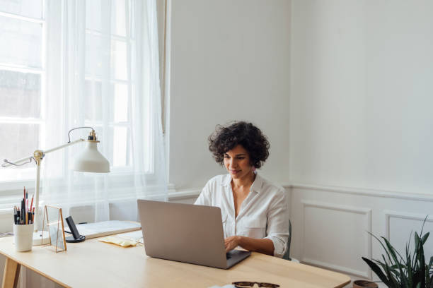 istock Beautiful Woman Working on Laptop Computer at Home 1340589364