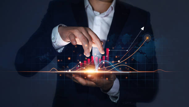 istock Businessman Holding Tablet with Growing Virtual Hologram of Statistics, Graph and Chart. Business Strategy Development and Growing Growth Plan 1340590725