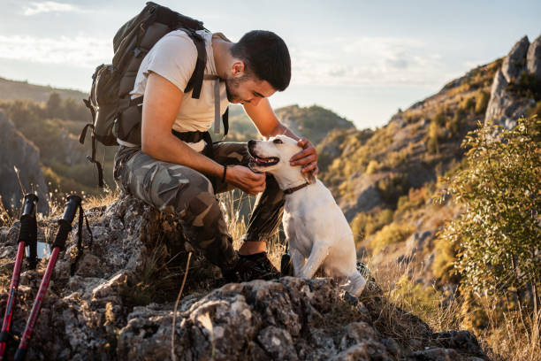 istock Man his best friend taking a break from hiking 1340591735