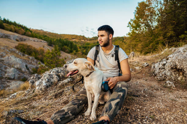 Man with his best friend taking a break from hiking