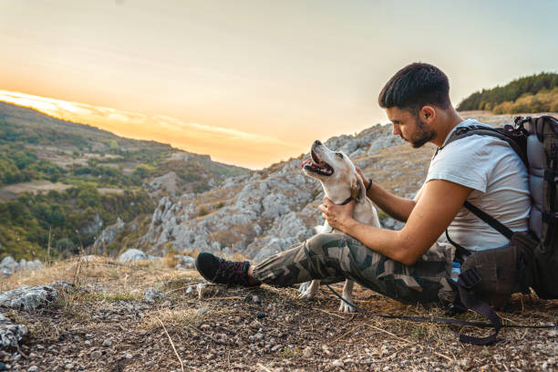 istock Man with his best friend taking a break from hiking 1340592369