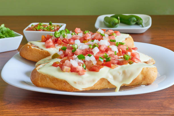 Molletes, typical Mexican food with pico de gallo sauce, beans and Manchego cheese for breakfast or lunch. Molletes, typical Mexican food with pico de gallo sauce, beans and Manchego cheese for breakfast or lunch. machego stock pictures, royalty-free photos & images