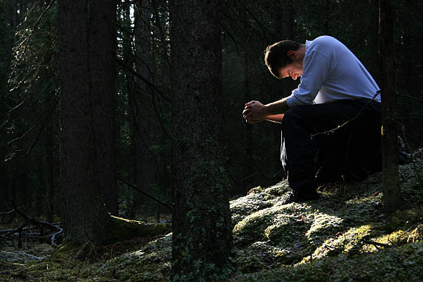 uomo di pregare nella foresta - sinner foto e immagini stock