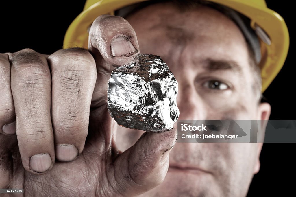 Silver miner with nugget A silver miner shows off his newly excavated silver nugget. Silver - Metal Stock Photo