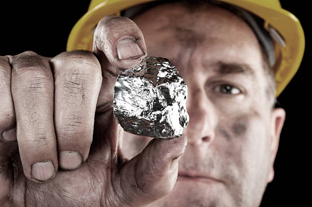 Silver miner with nugget A silver miner shows off his newly excavated silver nugget. metal ore stock pictures, royalty-free photos & images