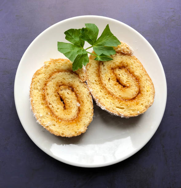 Swiss roll, also known as jelly roll filled with apricot jam and sprinkled with icing sugar.