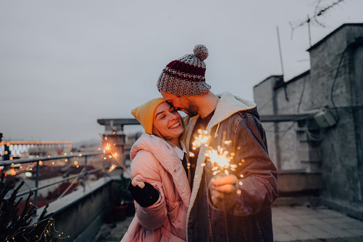 Photo of a romantic couple celebrating Christmas on a rooftop terrace