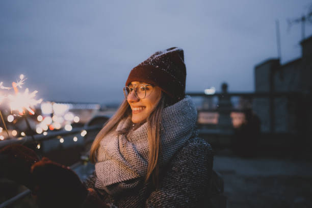 istock Young woman with sparklers on a rooftop terrace 1340598752