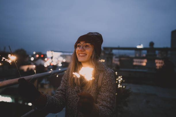 istock Young woman with sparklers on a rooftop terrace 1340598774