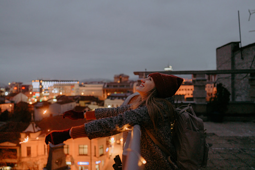 Photo of a young woman with sparklers on a rooftop terrace