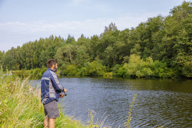 istock A man with a beard is fishing on the river. 1340599656