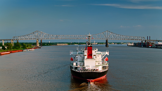Drone shot of a bulk carrier on the Mississippi River in New Orleans approaching the Crescent City Connection Bridge.