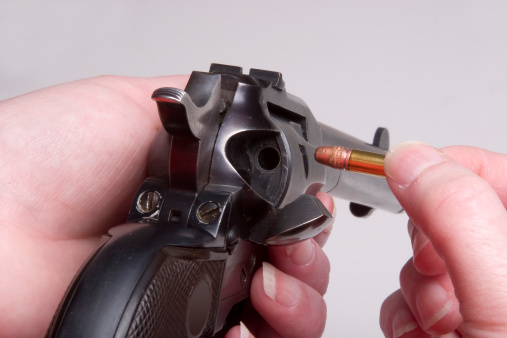 9mm pistol and bullet shells on black leather background, sunlight edited, soft and selective focus on pistol gun.