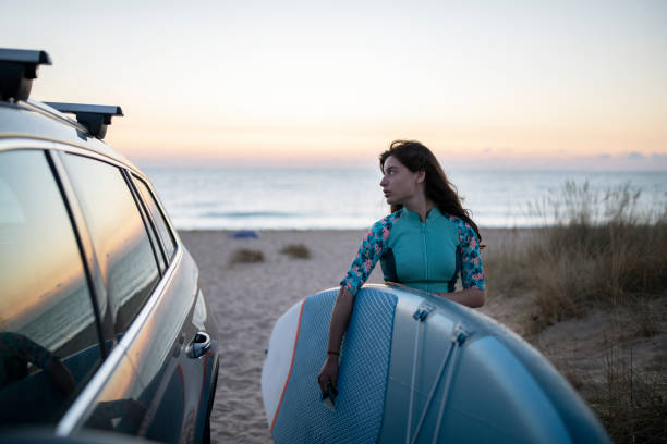 istock Woman Preparing For Surfing At Sunrise. 1340604435