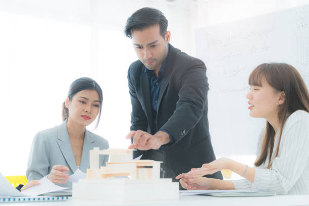 istock Engineer man looking and planning on mass building model. People meeting and brainstorm for new innovation for construction and architecture. Business of creative thinking of people. 1340610754