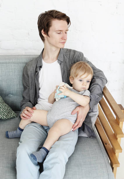 istock young father holds his little son in his arms 1340611920