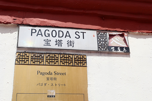 Two street signs for Pagoda street in Singapore's Chinatown district written in several languages.