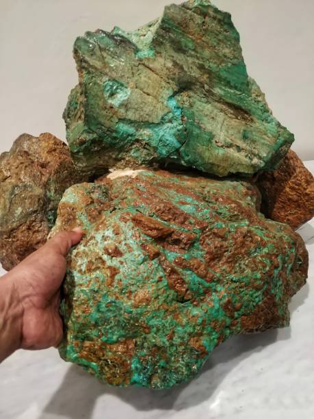 istock A man's hand is holding a large green nickel rock 1340617924