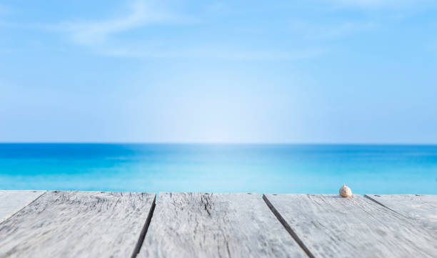 istock Wooden floor over blurred beach background 1340619727