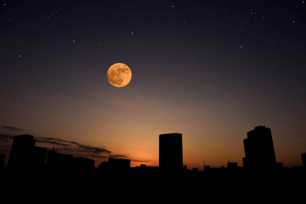 istock Full moon rising over the buildings at dusk. 1340621629