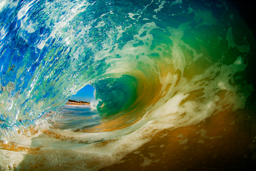Inside view of a sandy barreling wave.
