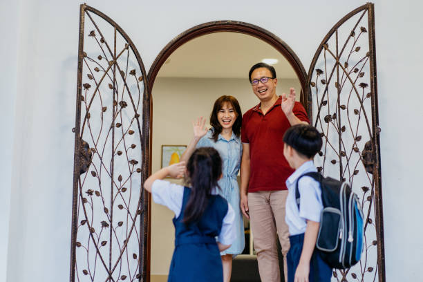 istock Young siblings in school uniform leaving house for school 1340627297