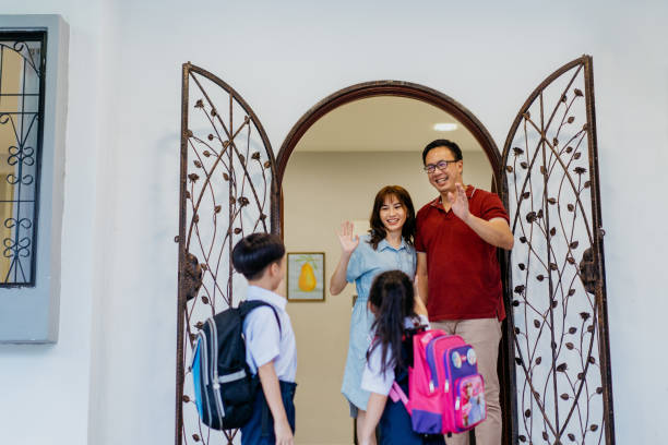 istock Young siblings in school uniform leaving house for school 1340627303